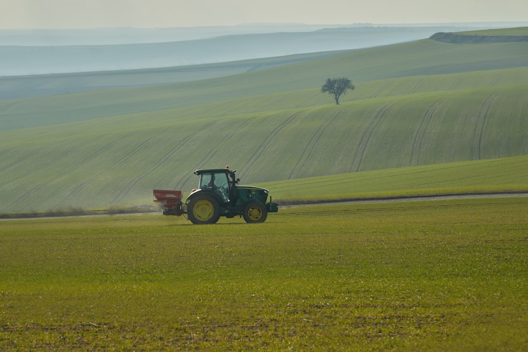 a-tractor-is-driving-through-a-green-field-6i7-iykriss