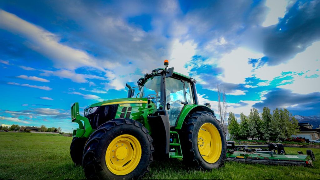 a-tractor-parked-in-a-field-with-a-blue-sky-in-the-background-sm1xjw7dwdw